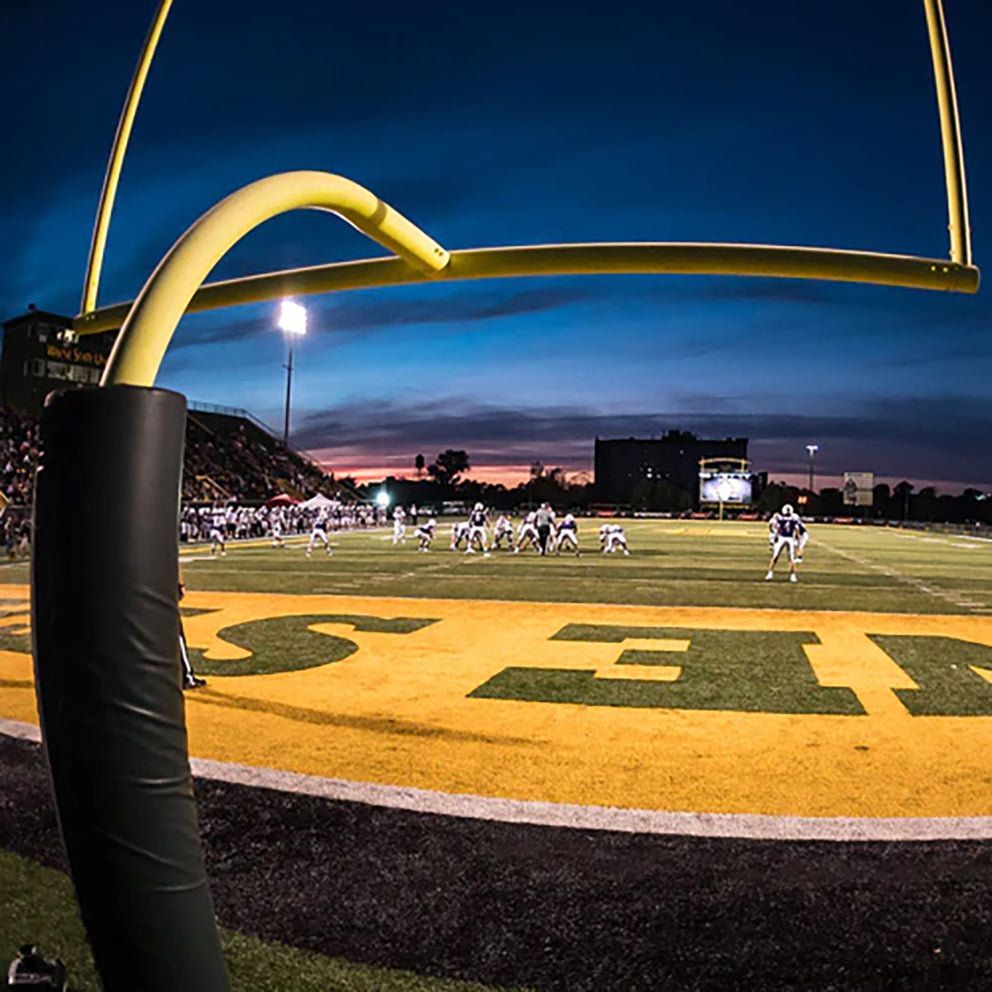 Wide shot of a football field from the back of an end zone.