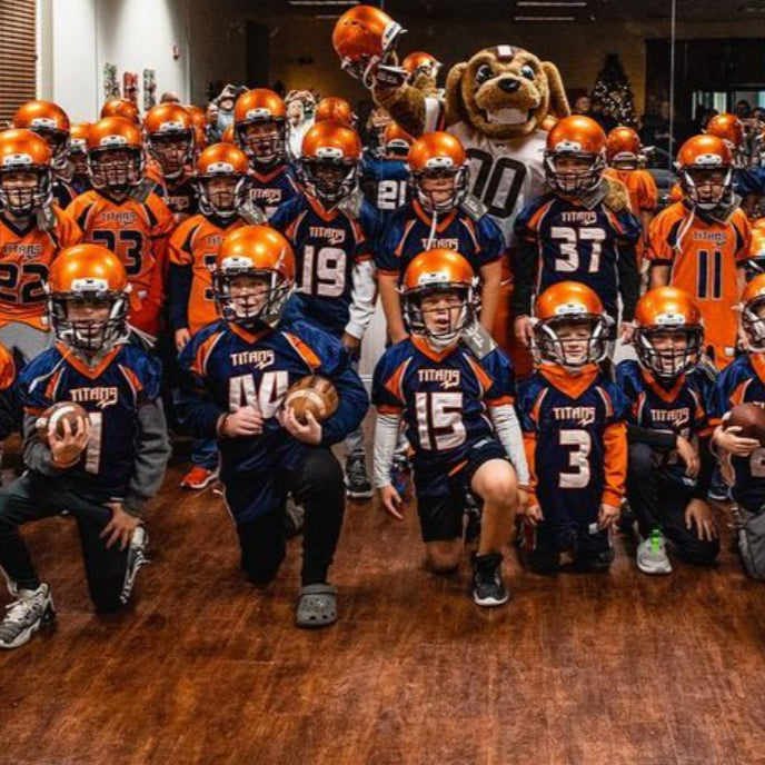 Athletes posing together wearing new Xenith football helmets.