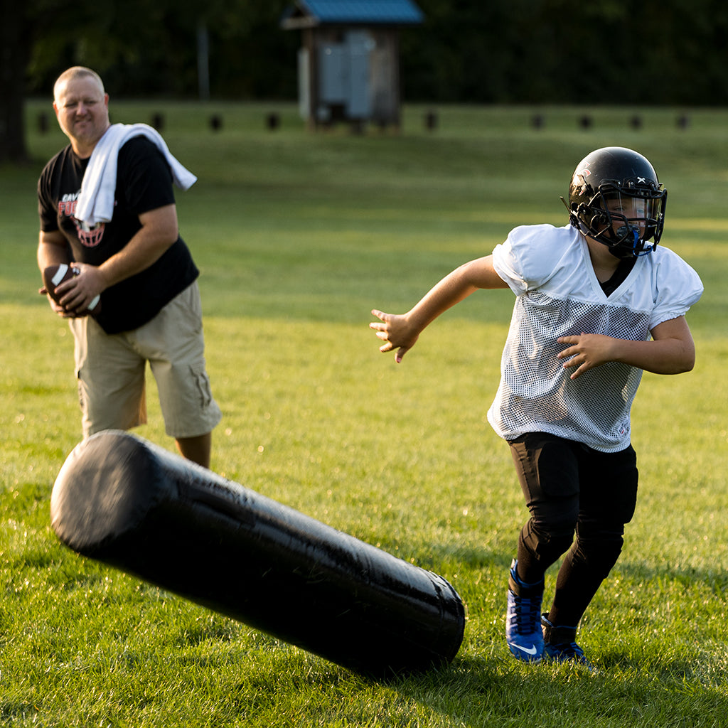 A father and son practicing football drills.