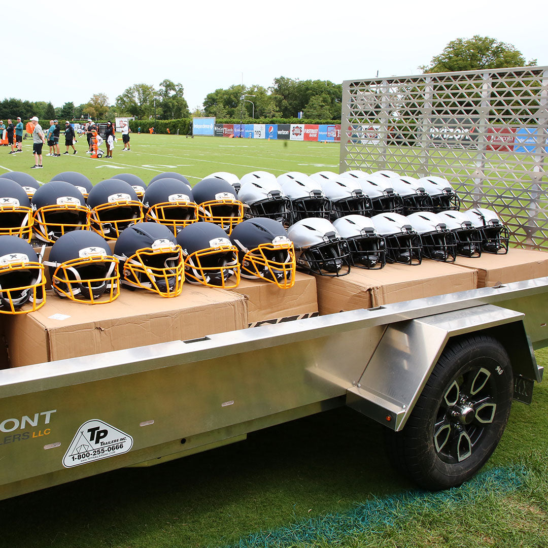 Xenith football helmets displayed side-by-side on a trailer.