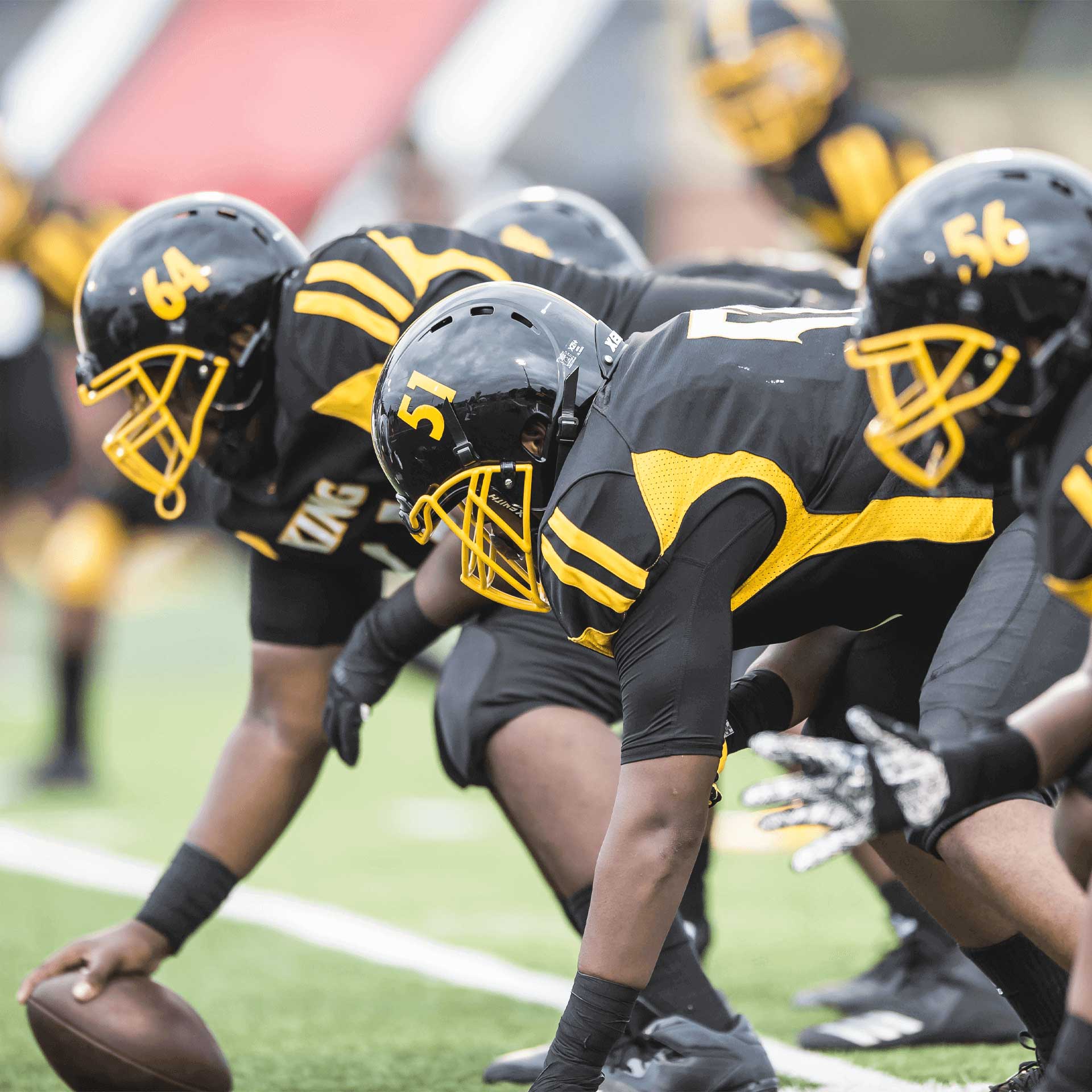 Close-up of football players lined-up for the snap.