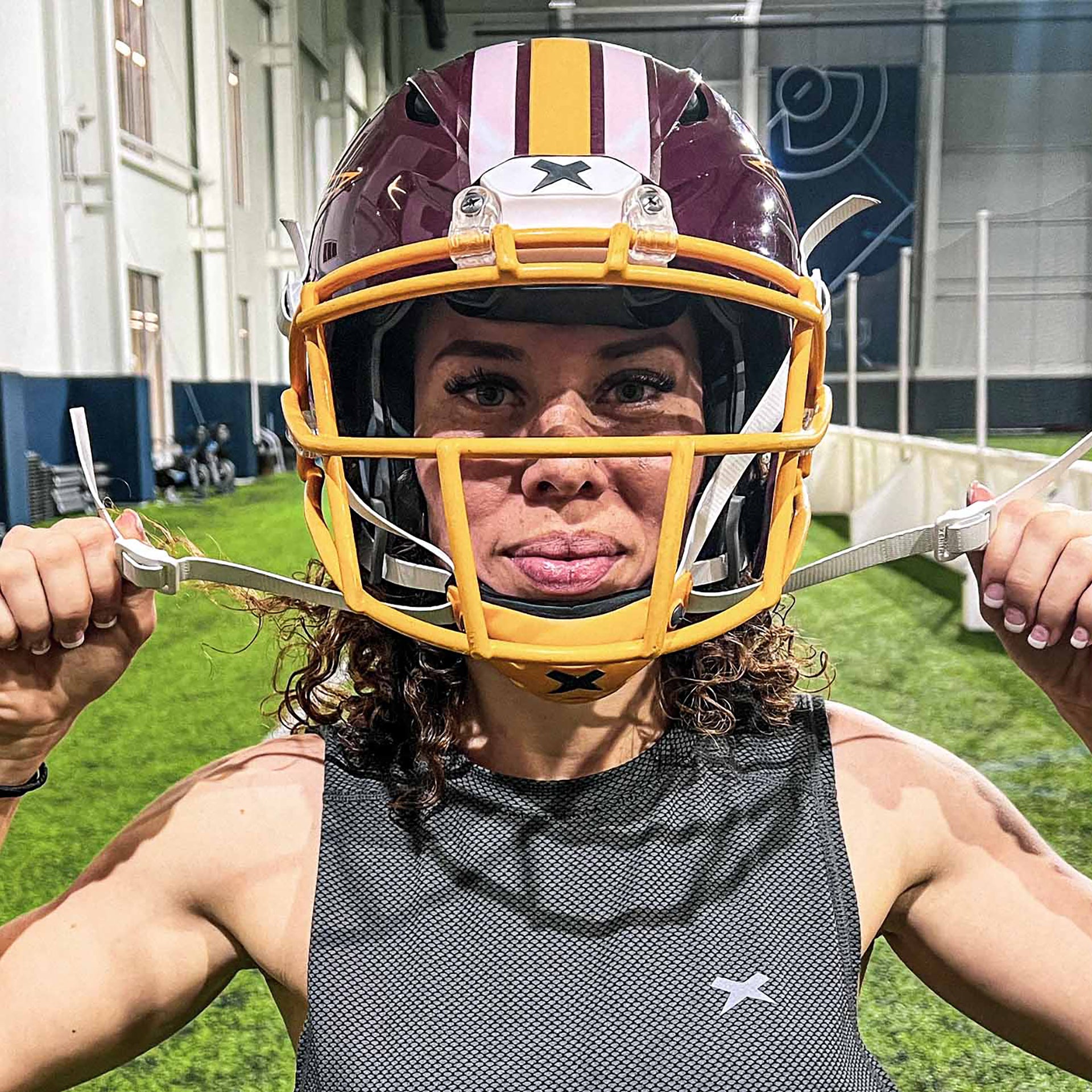 Close-up of Lois Cook wearing a football helmet.