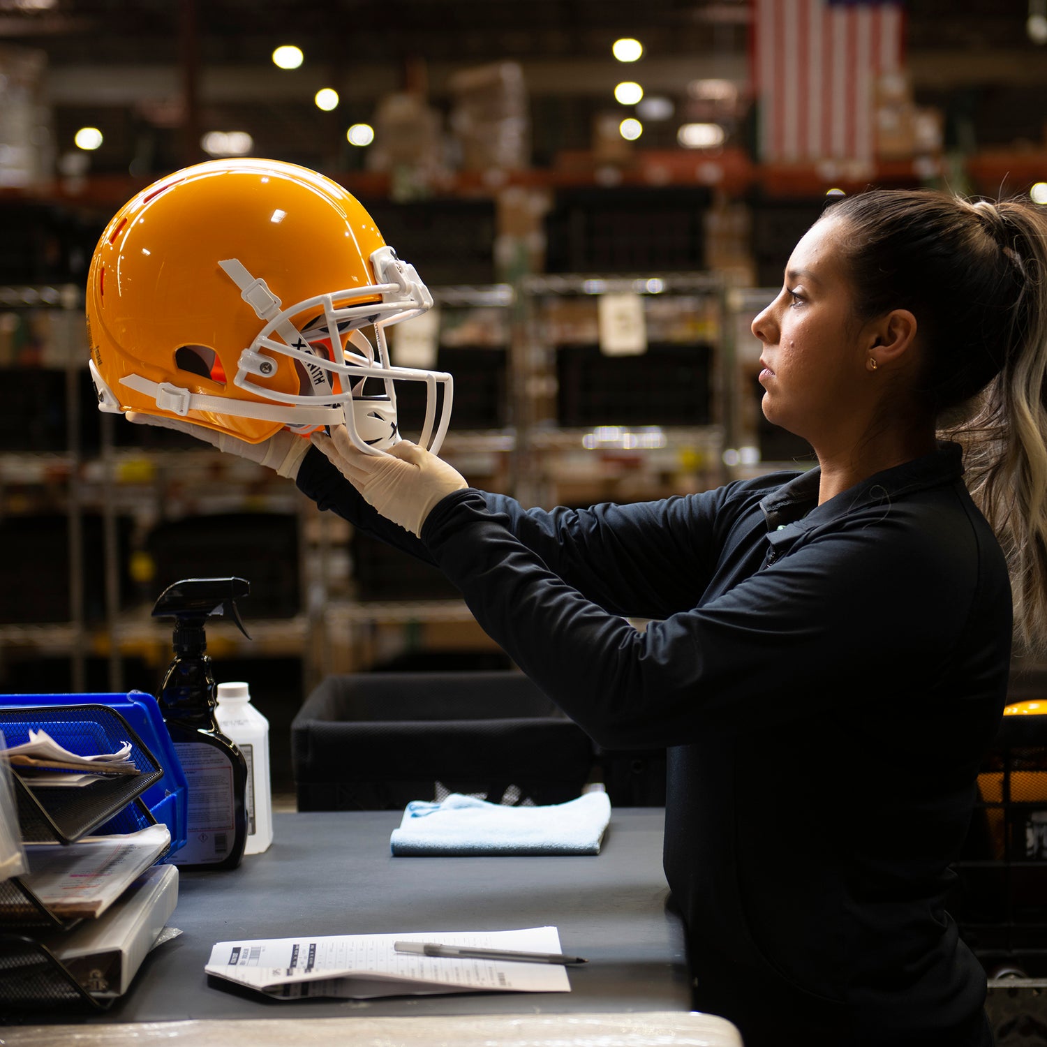 Side-view of a person holding a football helmet at eye-level.