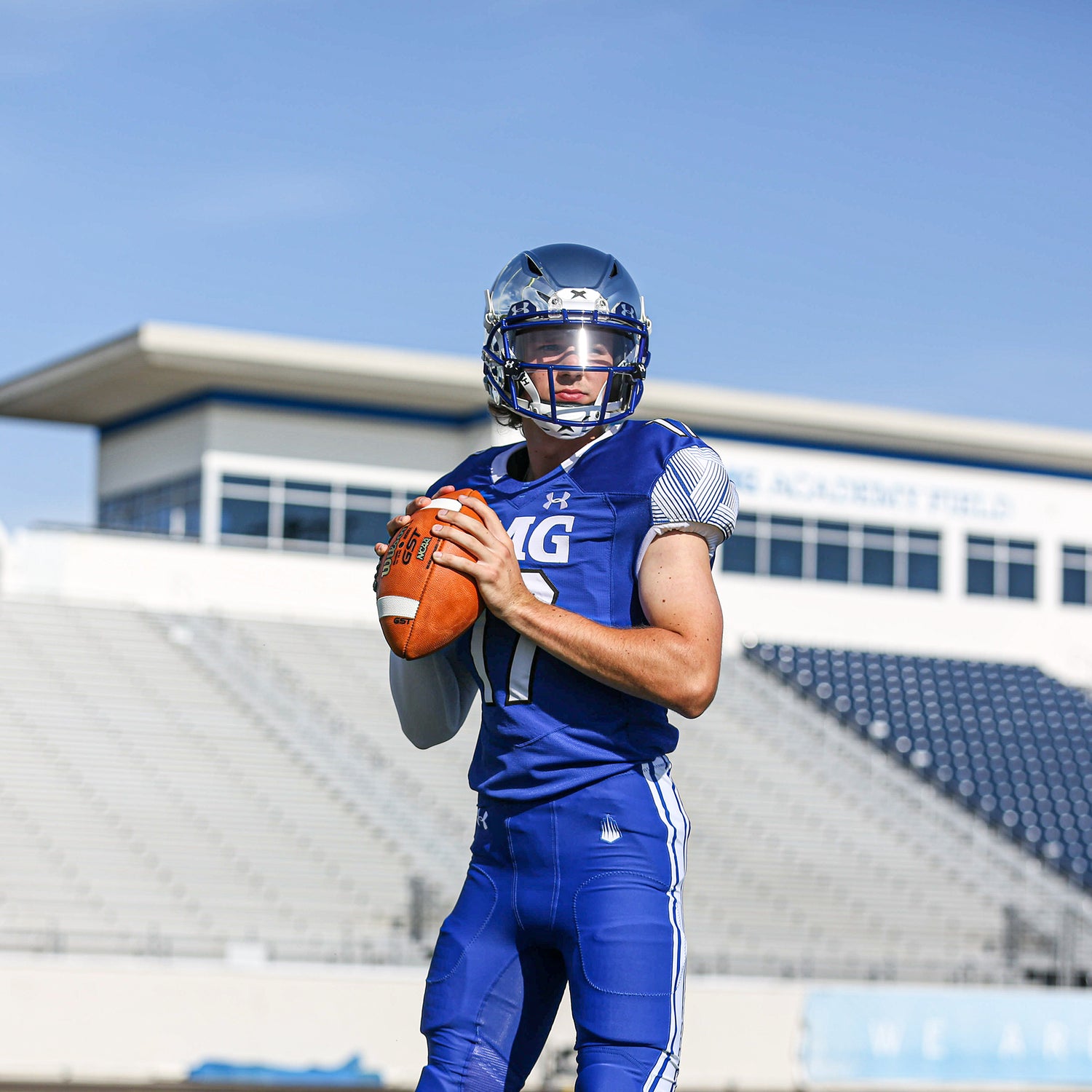 Front-side view of a quarterback holding a football.