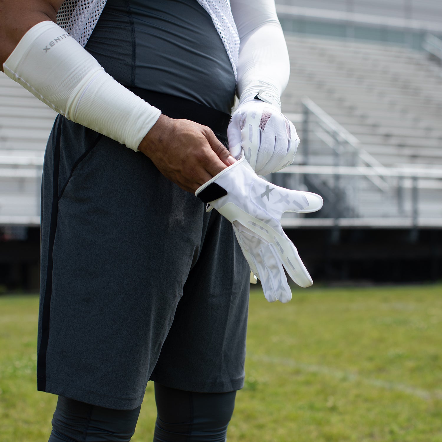 A football player putting on Xenith Performance Football Gloves.