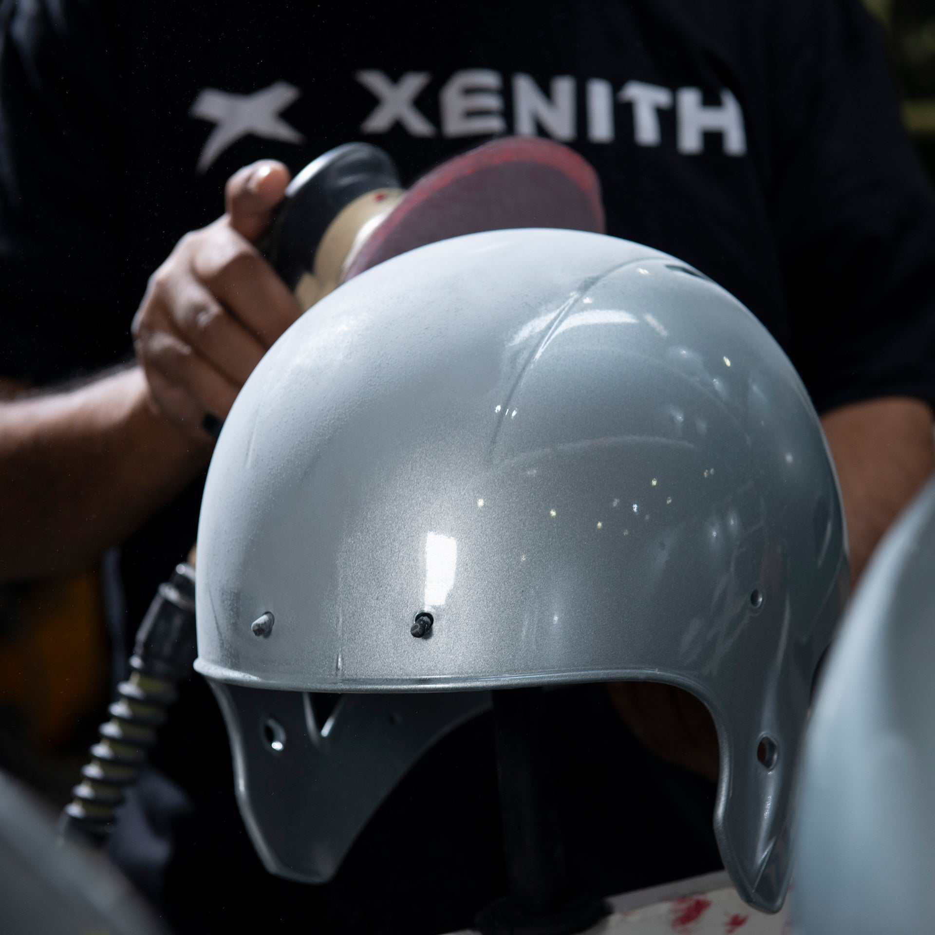 A member of Xenith's reconditioning team buffing helmets during reconditioning.