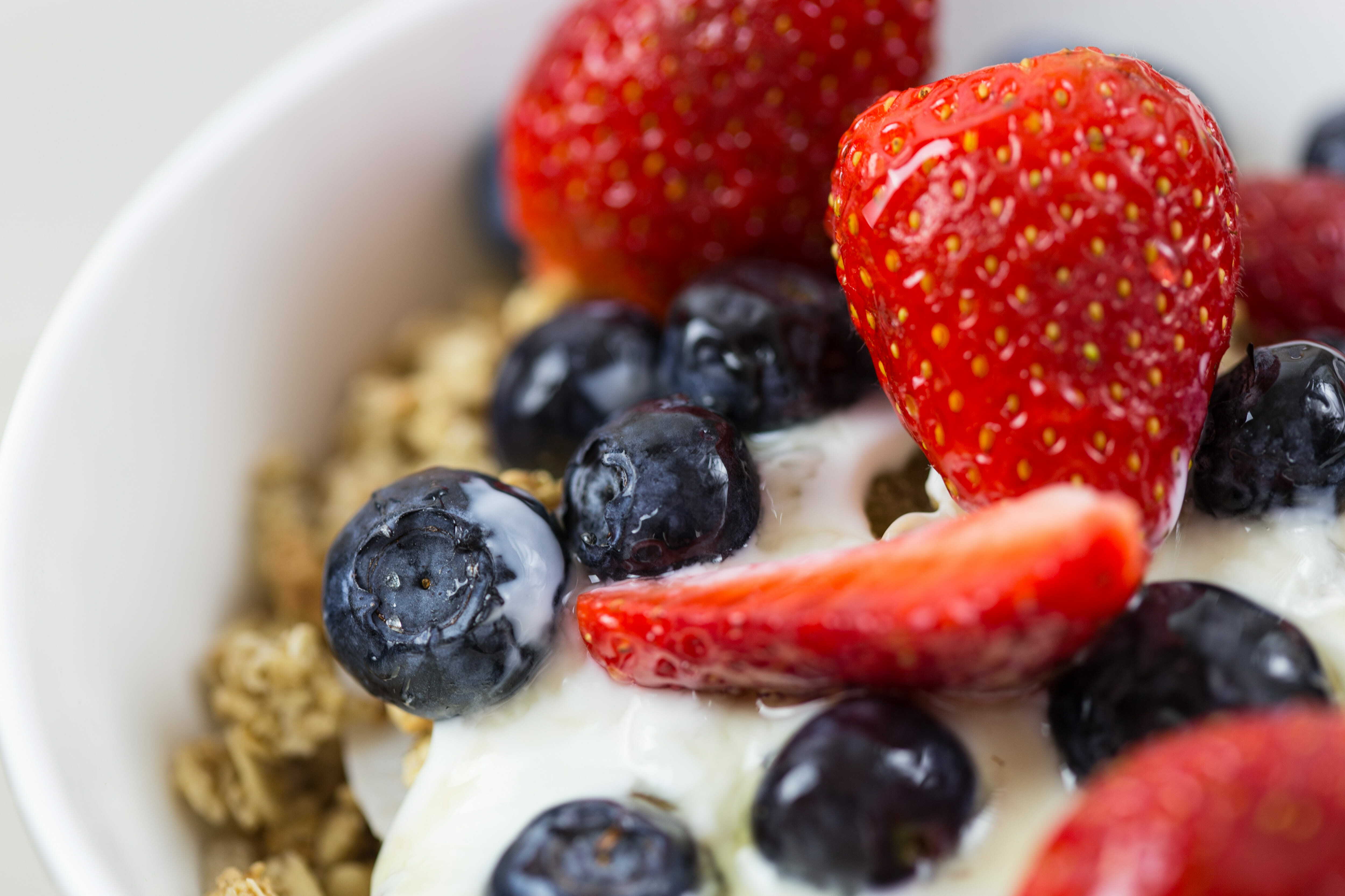 Close up of a bowl of fruits, yogurt and oats.