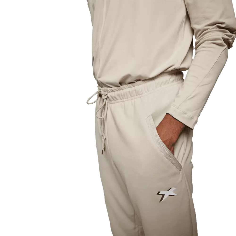 Male model wearing black jogger pant with reflective Xenith-X logo and hand in pocket, from profile.