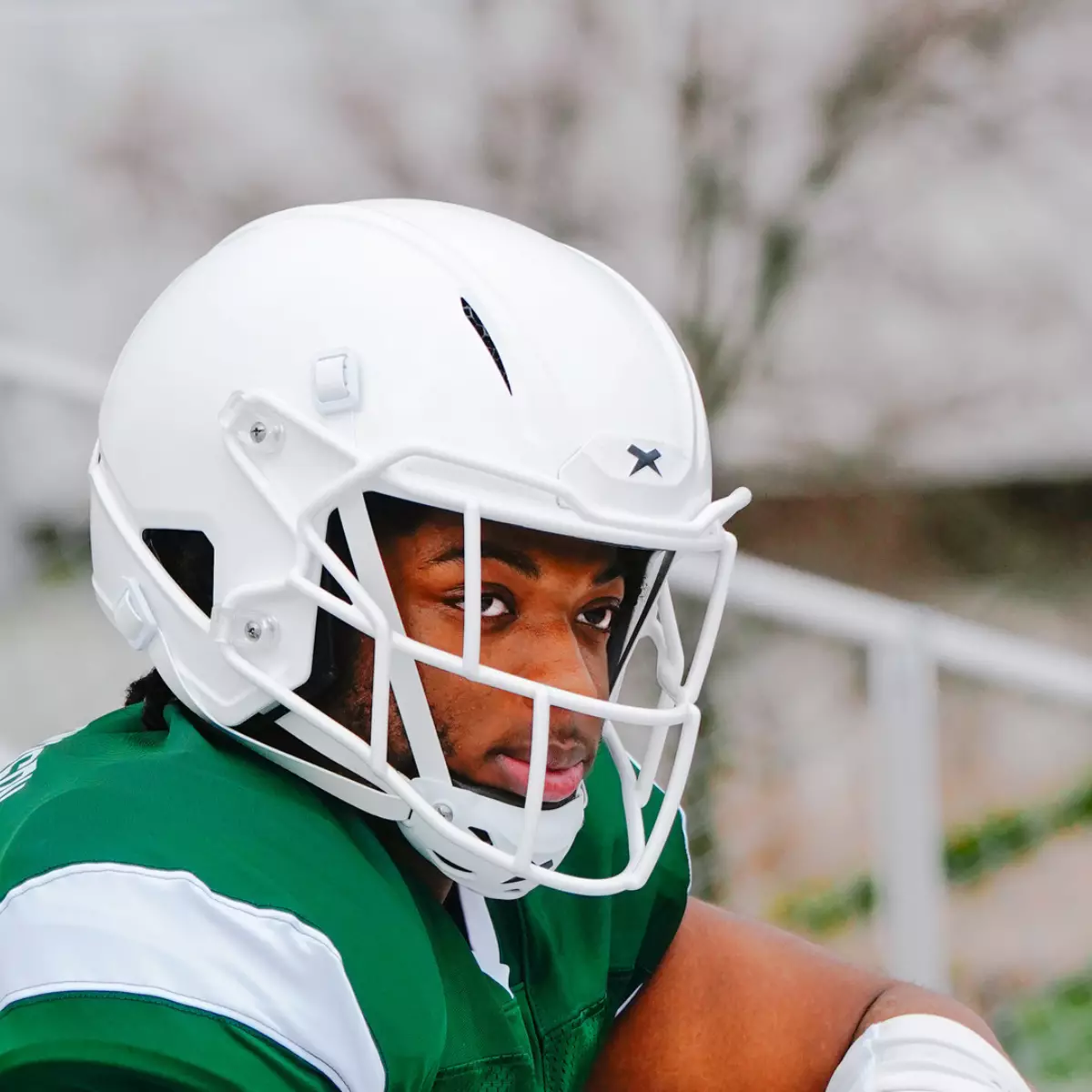 Close up of a football player wearing a white Xenith helmet.