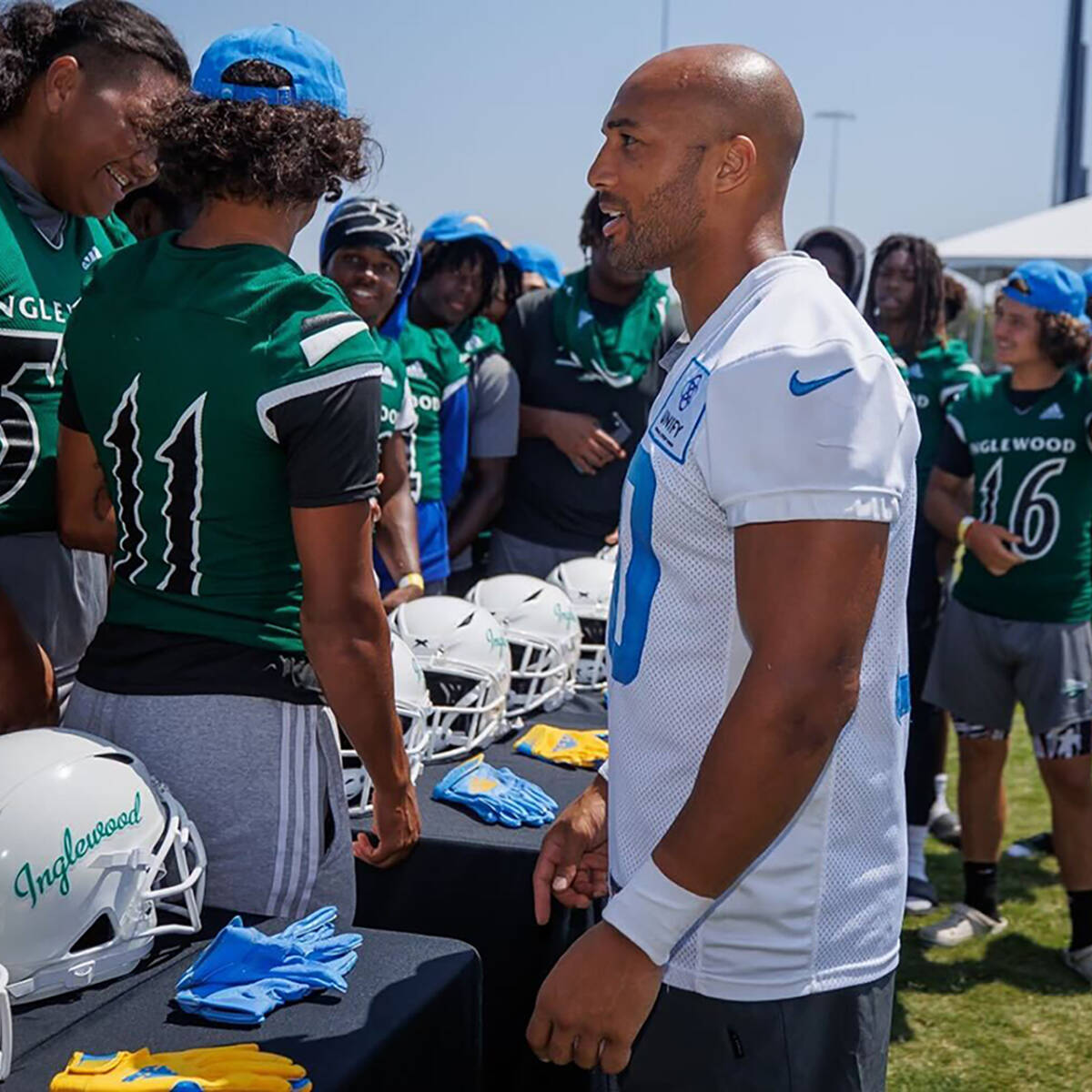 Austin Ekeler talking to Inglewood football players while checking out the new equipment donated by the Austin Ekeler Foundation.