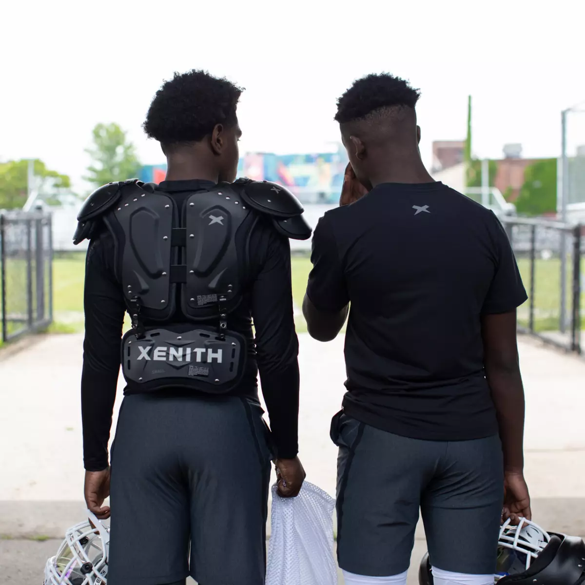 Two athletes facing away from the camera wearing Xenith football gear.