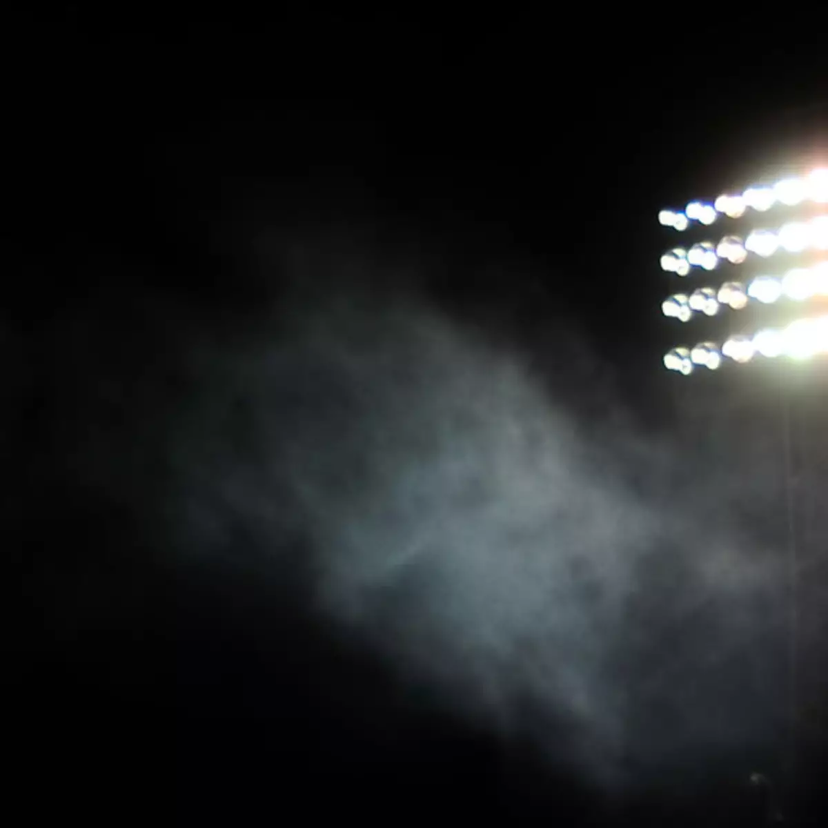 Dark sky with stadium lights shining on the right side.