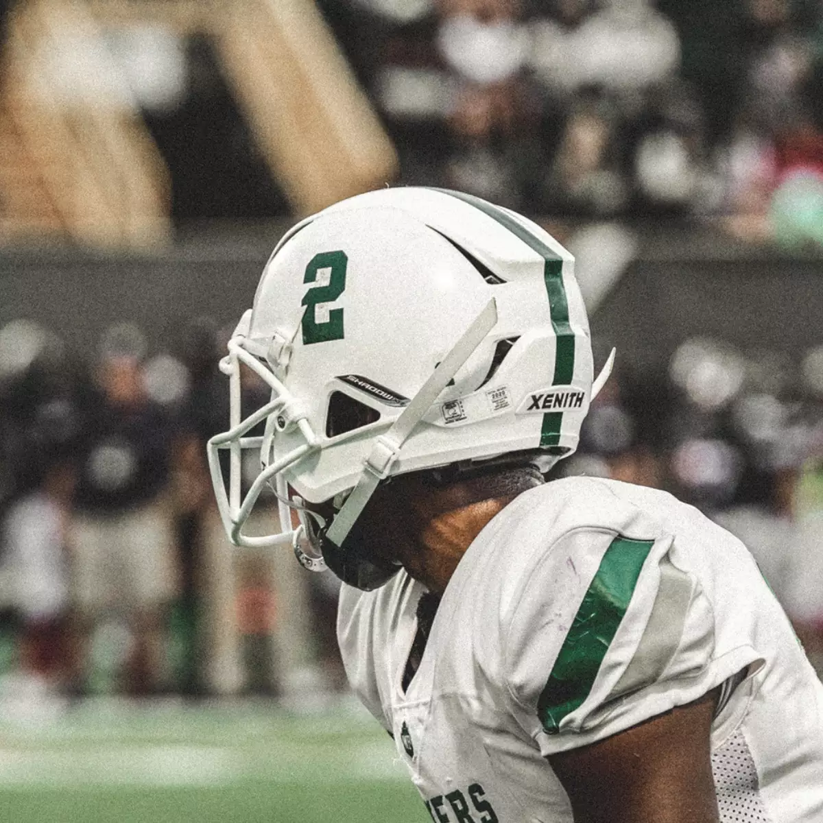 A football player lining up before a play looking away from the camera.