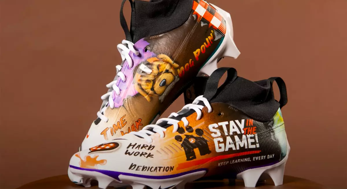 Close up of football cleats displayed against a brown background.