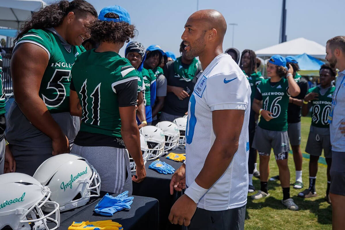 Austin Ekeler talking to Inglewood football players while checking out the new equipment donated by the Austin Ekeler Foundation.