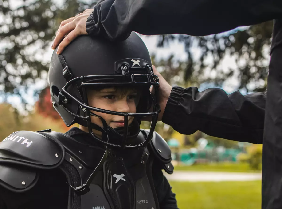 A youth athlete getting fitted for a Xenith helmet.