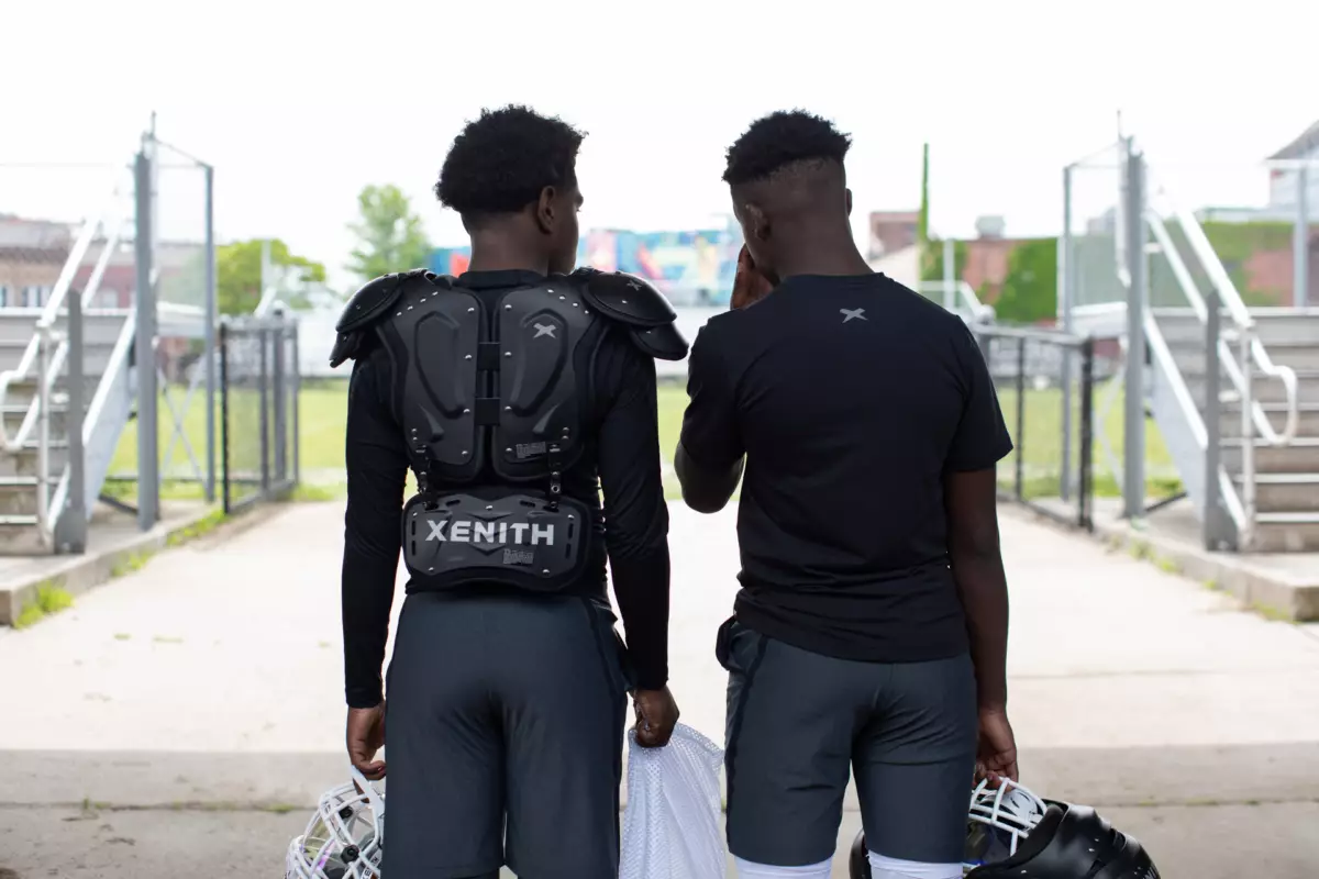 Two athletes facing away from the camera wearing Xenith football gear.