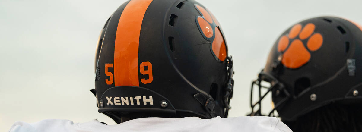 Close up of two athletes wearing Xenith X2E+ helmets facing away from the camera.