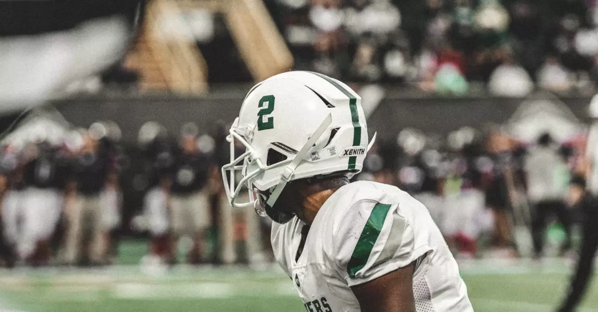 A football player lining up before a play looking away from the camera.