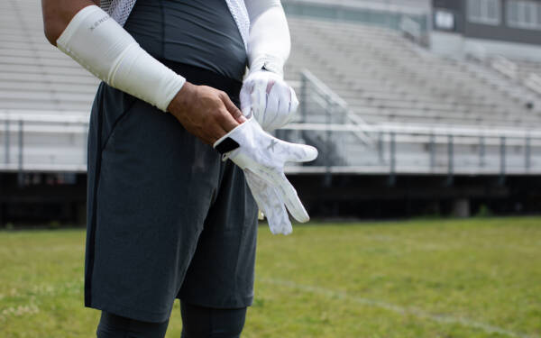 A player putting on Xenith Precision Receiver gloves.
