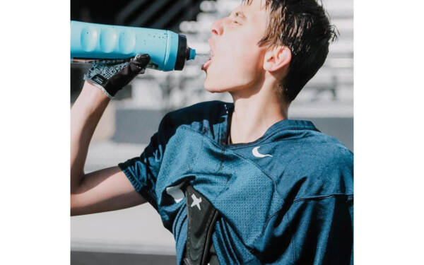 A youth athlete drinking water.
