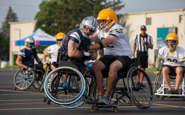 A wheelchair football player runs into another during a play.