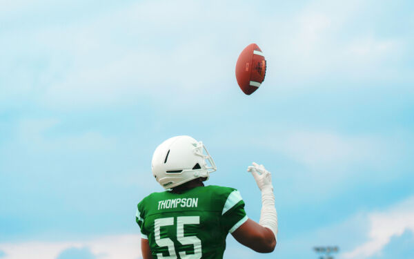 Backside view of Jalen Thompson tossing a football in the air.