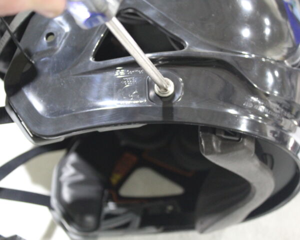 Close up view showing how to remove the screw under the earhole of a Xenith Shadow helmet.