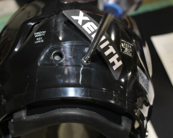 Close up view showing how to remove the screw from the back of a Xenith Shadow helmet.