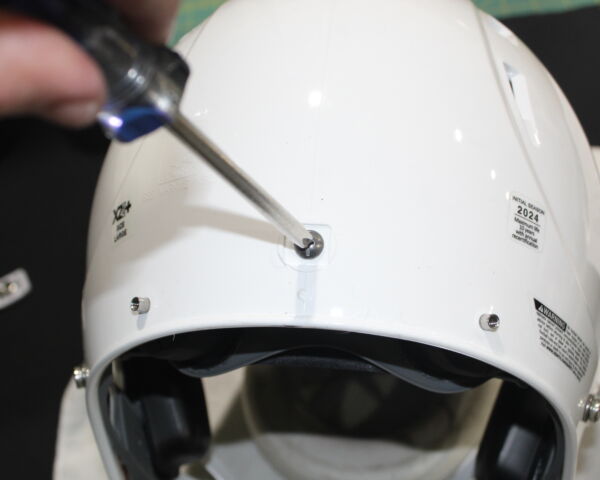 Close up view showing how to remove the screw from the back of a Xenith X2E+ helmet.
