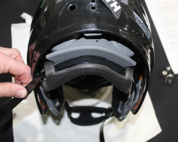 Close up view showing backside of the helmet and the chin strap threaded through the shock liner.