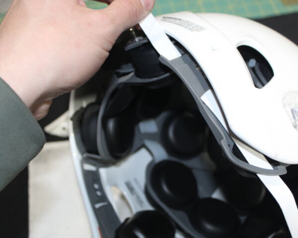 Close up view showing how to pull the chin strap through a Xenith X2E+ shock liner.