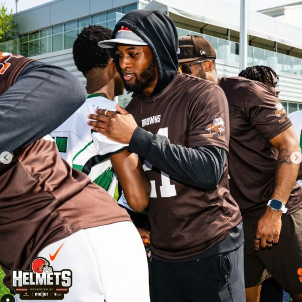 A Browns player shakes hands with a Bedford High School player.