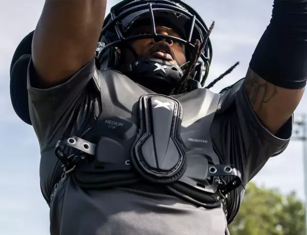 Close up of a football player catching a pass with Xenith shoulder pads and helmet on.