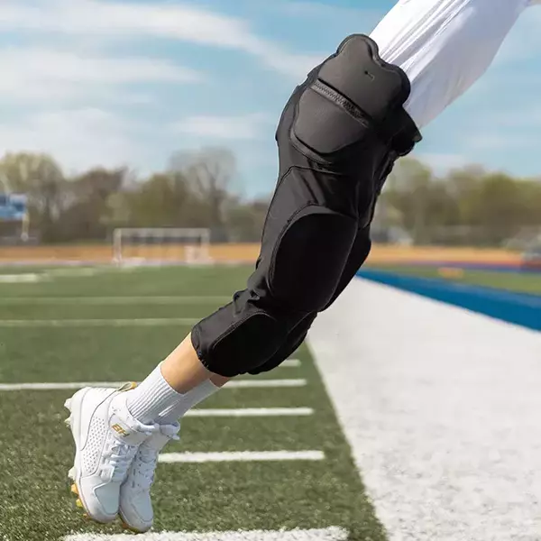 Close up side view of player on field wearing Xenith Integrated Pants Black.