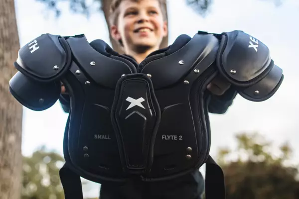 Flyte 2 youth shoulder pads from the front being held by a player.
